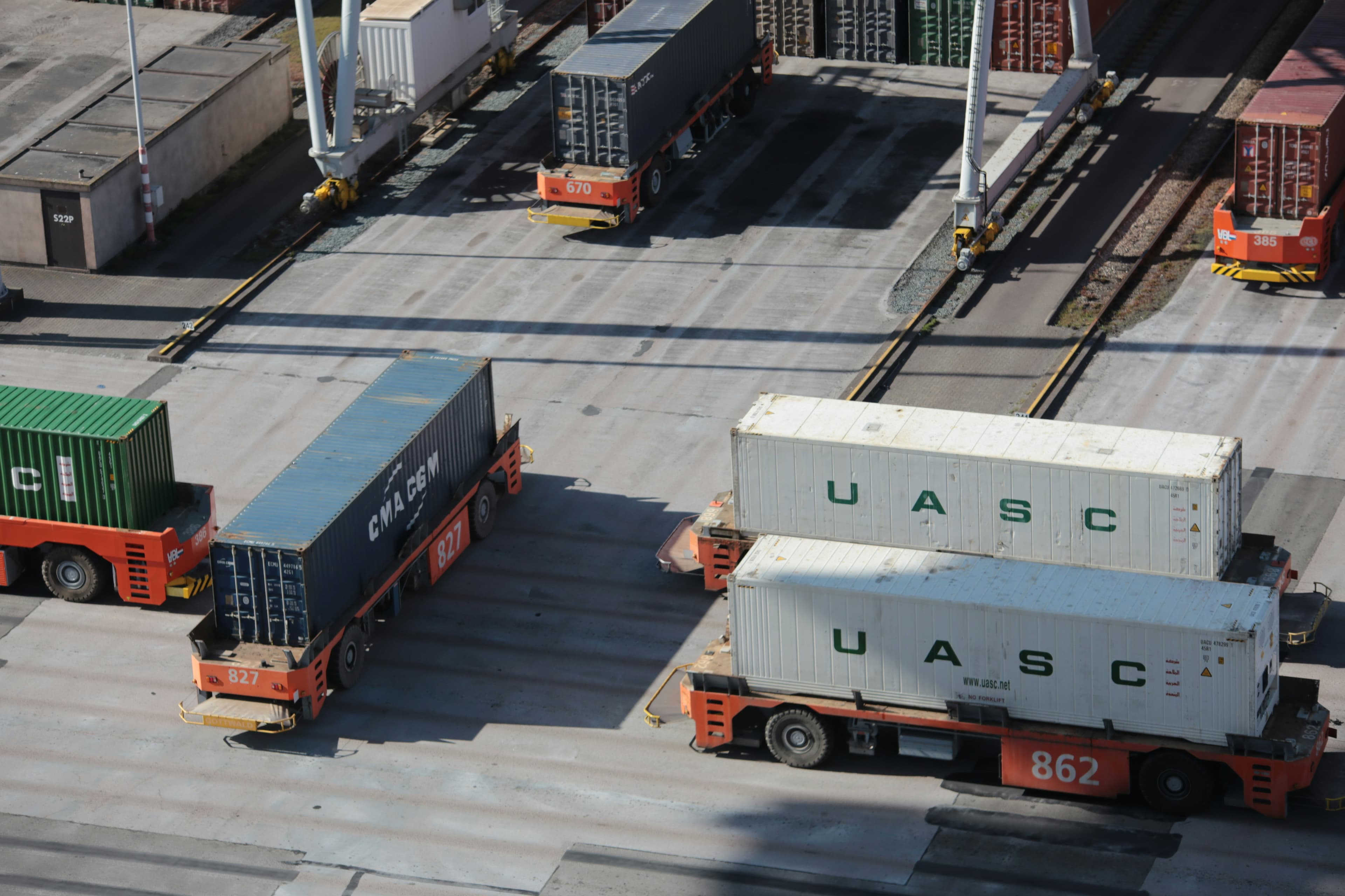 Automated cargo containers moving through a modern shipping terminal.